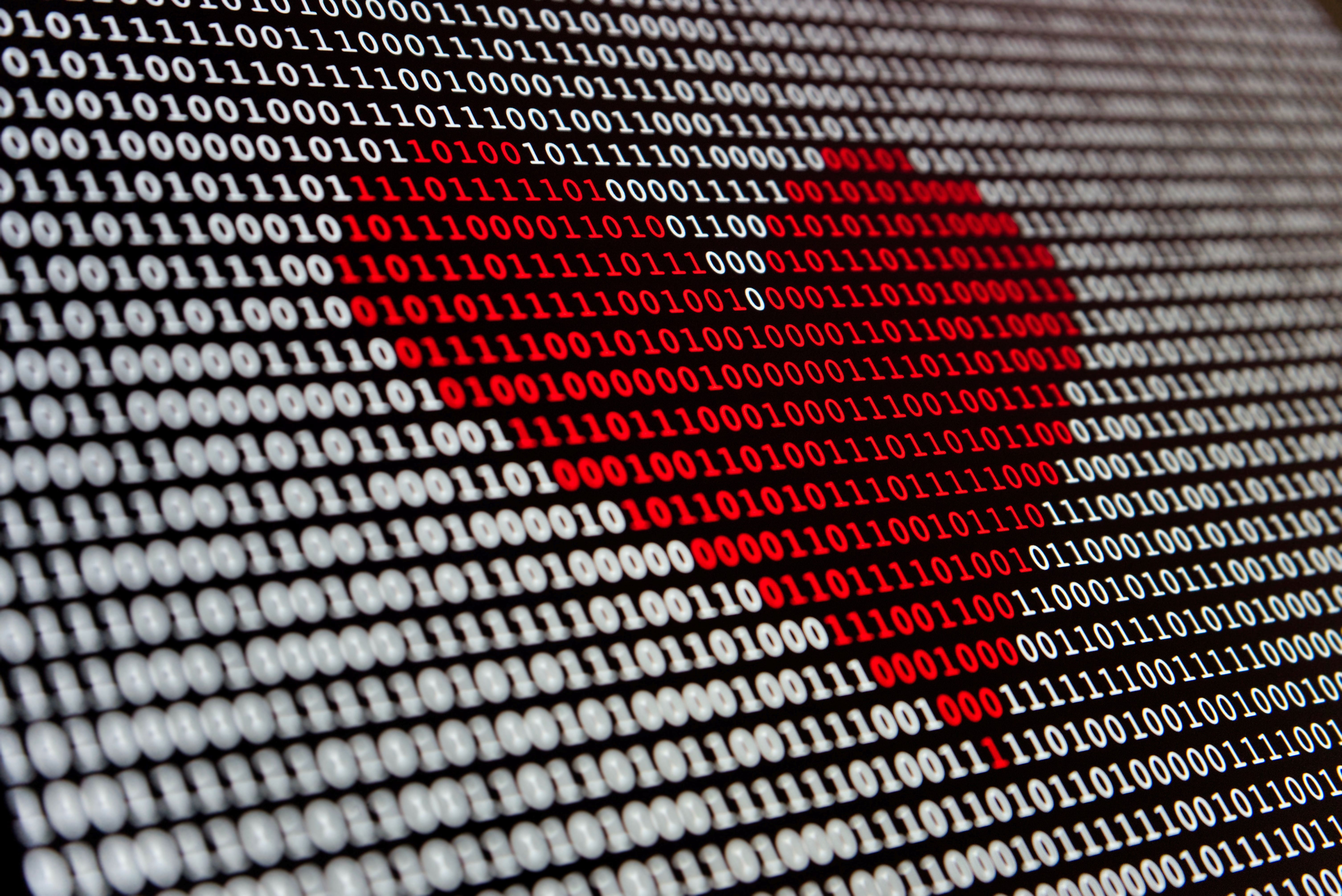 Computer screen filled with binary numbers and a red heart in the middle to represent a love for technology and Artificial Intelligence (AI).