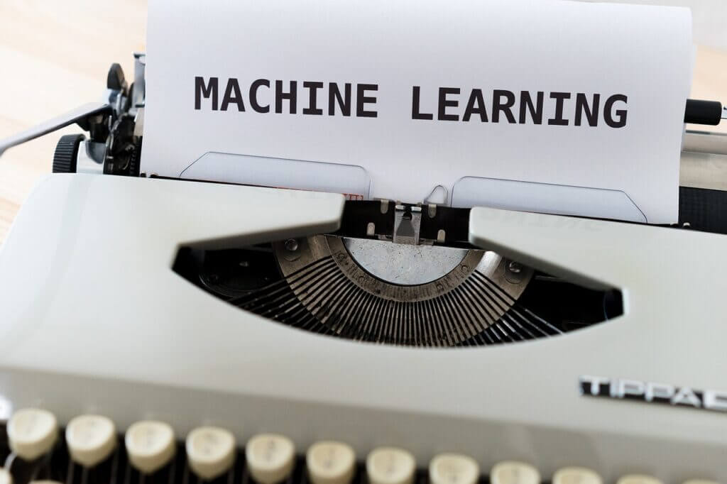 Typed piece of paper in an old fashion type writer with the words 'Machine Learning'. Machine Learning is one part of Artificial Intelligence (AI).
